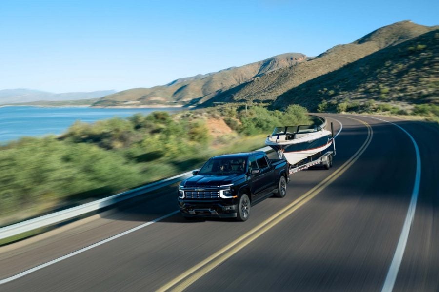 High Country towing a boat Black 2027 Chevrolet Silverado 1500 High Country towing a boat on a lakeside highway
